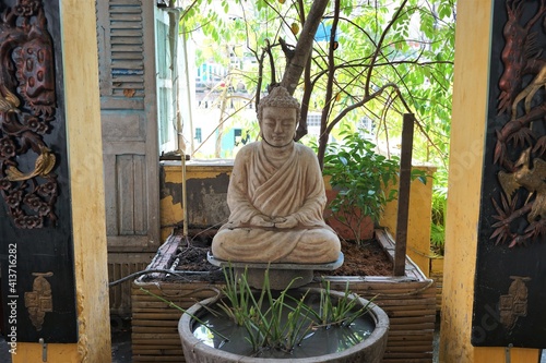 Wooden buddha statue on green background -              