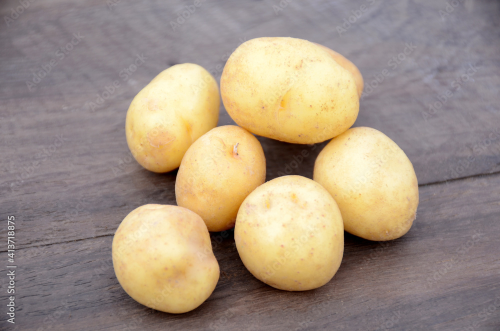 bunch the fresh ripe potato on the wooden background. bunch the fresh ripe potato on the wooden background.