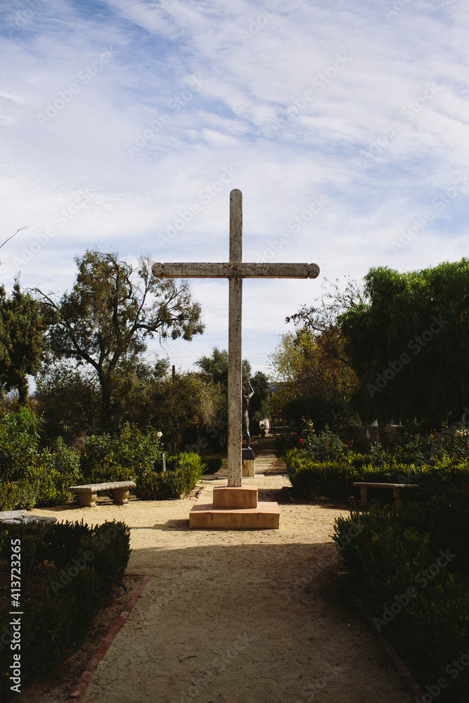 Cross on footpath against cloudy sky at park Cross on footpath against cloudy sky at park