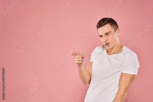 Emotional man gesturing with his hands white t-shirt pink isolated background