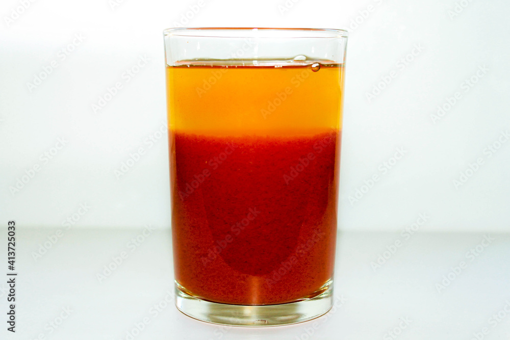 A glass of red tomato juice on a white background. A glass of red tomato juice on a white background.