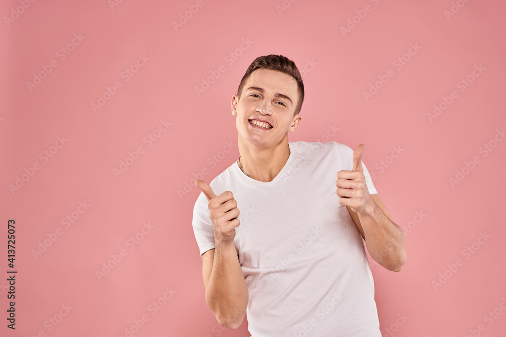 Emotional man gesturing with his hands white t-shirt pink isolated background Emotional man gesturing with his hands white t-shirt pink isolated background