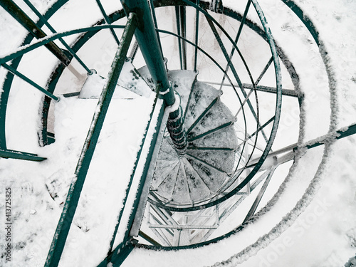 Snowy staircase of steel viewtower. Top view of steel winding slippery stairs photo