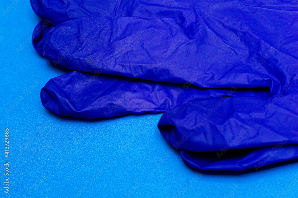Fototapeta premium blue medical surgical gloves on a blue background close-up