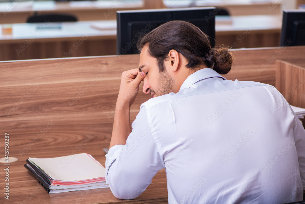 Young male employee and too many work in the office Young male employee and too many work in the office
