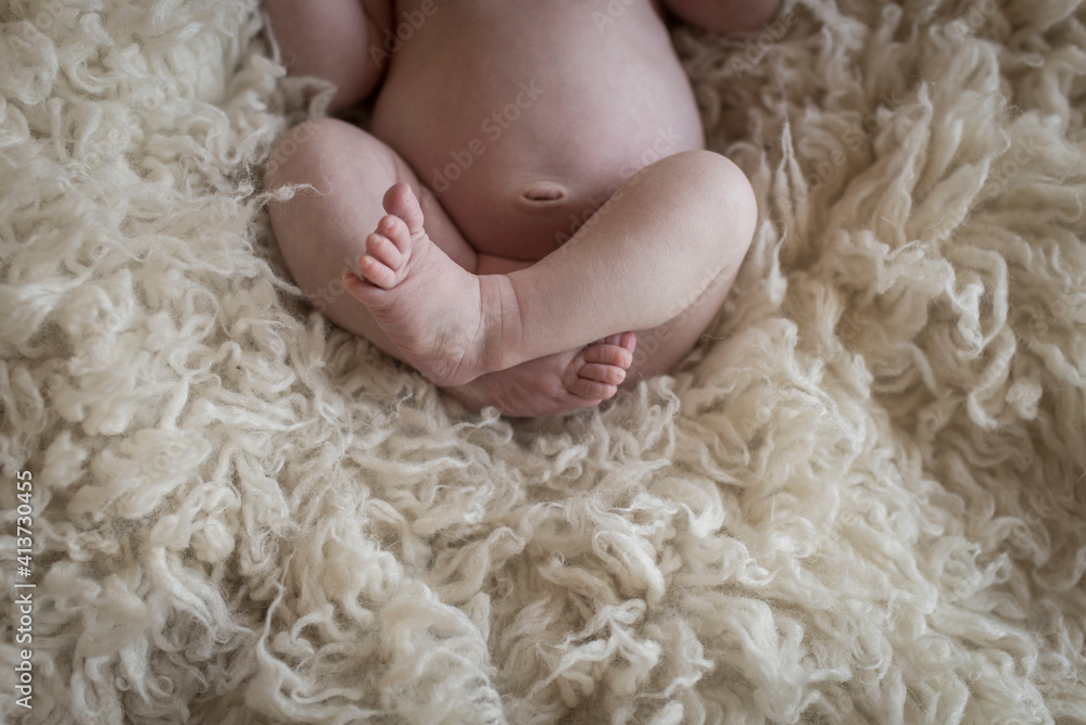Low section of baby boy lying on rug Low section of baby boy lying on rug