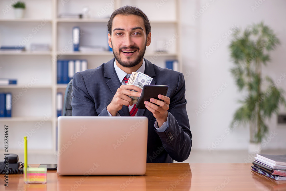 Young male bookkeeper holding banknotes and calculator Young male bookkeeper holding banknotes and calculator