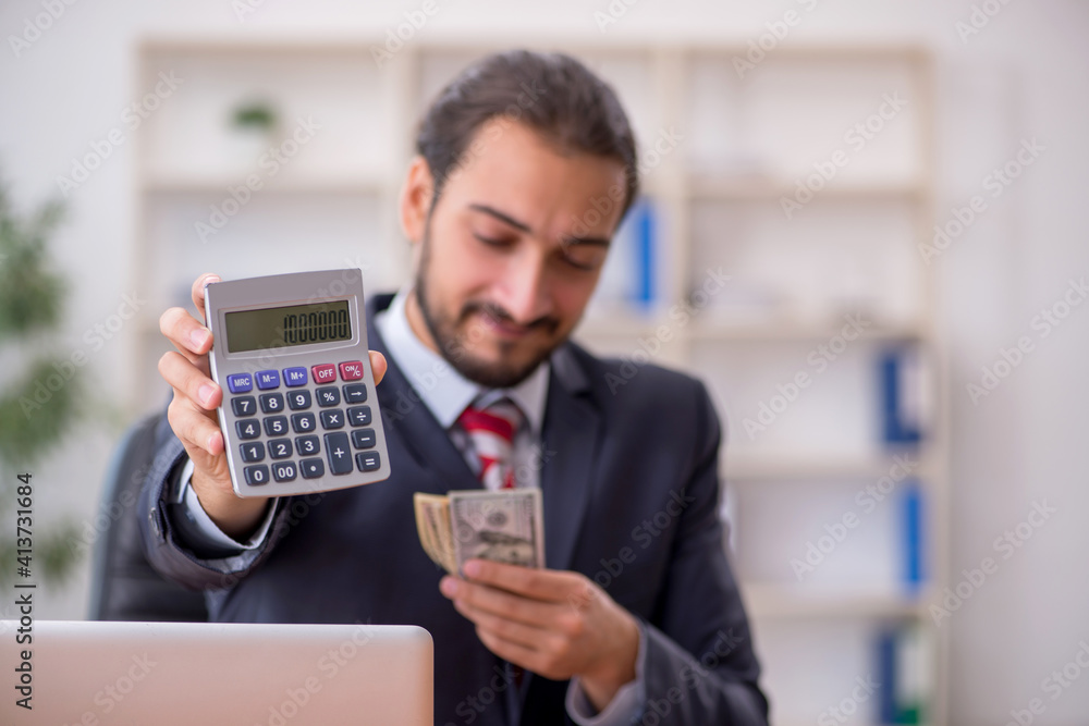 Young male bookkeeper holding banknotes and calculator Young male bookkeeper holding banknotes and calculator