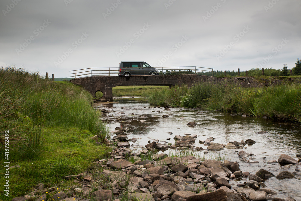Motor home moving on bridge over river against cloudy sky Motor home moving on bridge over river against cloudy sky