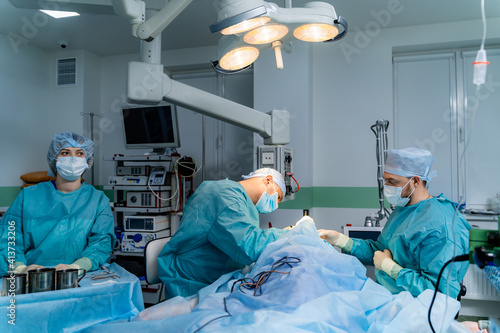Team of Surgeons Operating. Modern equipment in operating room.