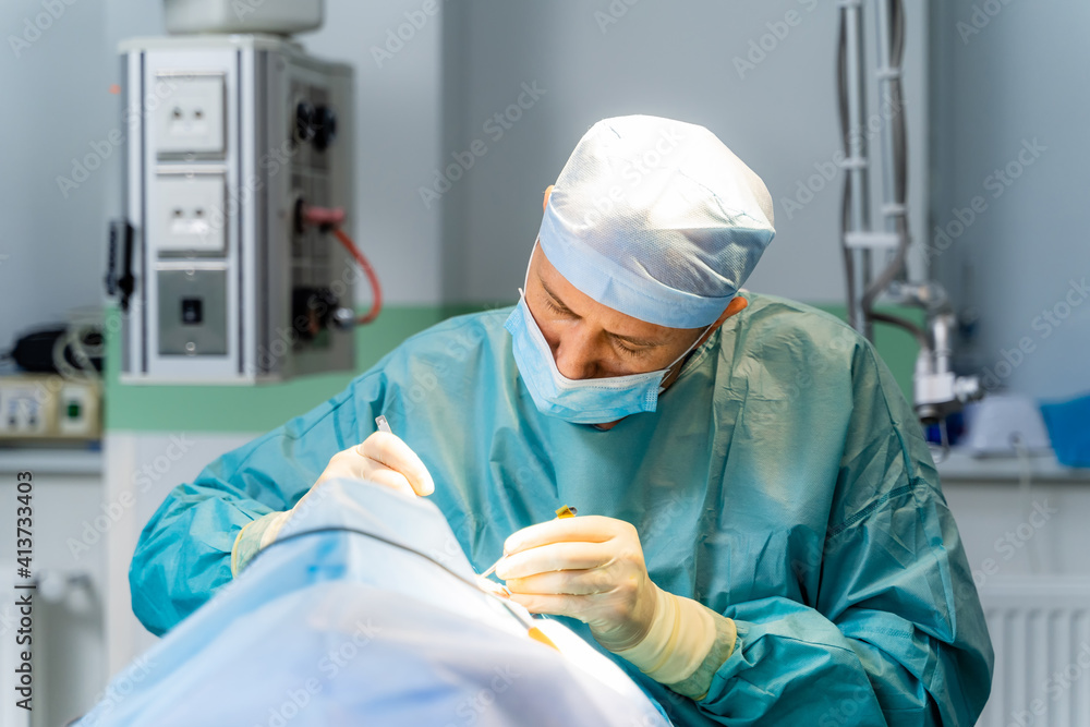 Surgeon in operation room. Working with surgical instruments. Modern equipment in operating room. Surgeon in operation room. Working with surgical instruments. Modern equipment in operating room.
