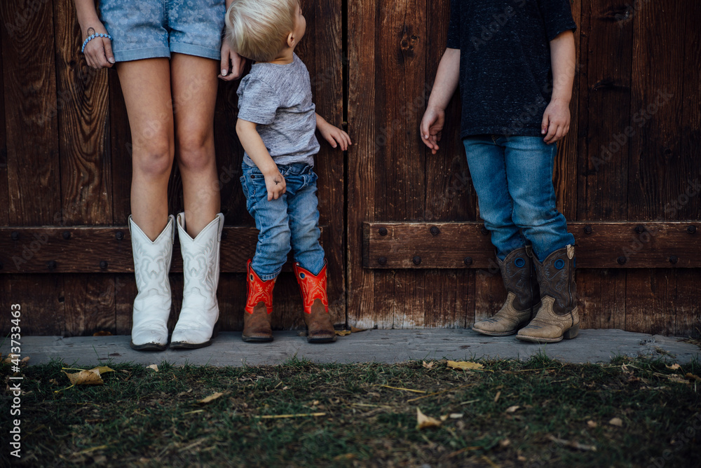 Siblings standing by wooden door Siblings standing by wooden door
