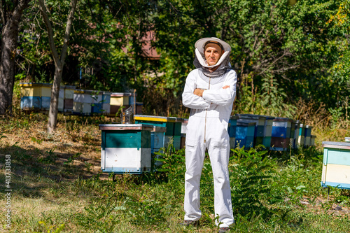 Portrait of happy male beekeeper. Beekeeper is working with bees and beehives on the apiary.