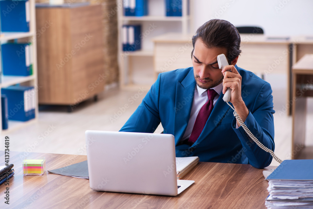 Young male employee working at workplace Young male employee working at workplace