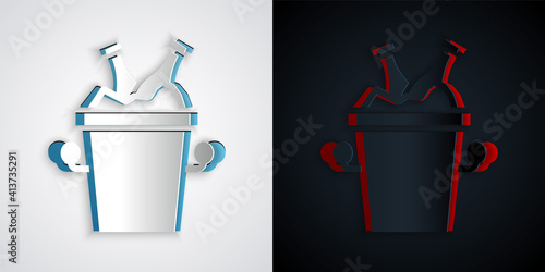 Paper cut Beer bottles in ice bucket icon isolated on grey and black background. Paper art style. Vector.