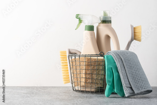 Brushes, sponges, rubber gloves and natural cleaning products in the basket.  Eco-friendly cleaning products photo