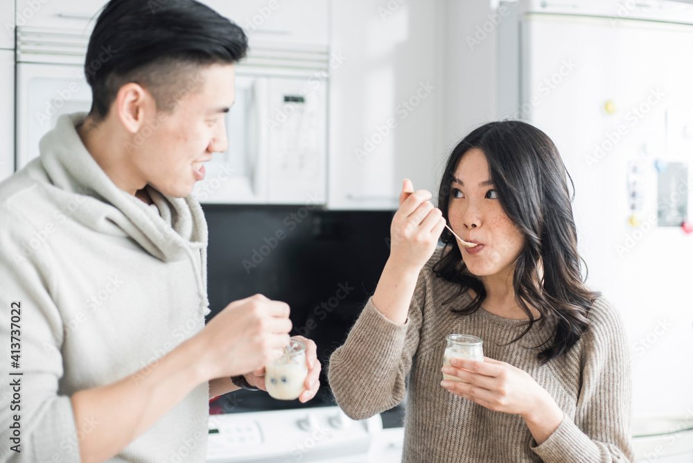 Happy couple eating breakfast in kitchen Happy couple eating breakfast in kitchen