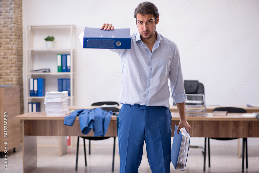 Young male employee doing sport exercises during break