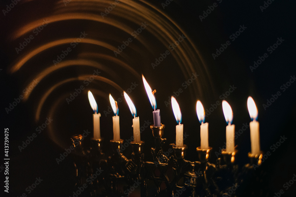 Close-up of Hanukkah Menorah candles glowing in darkroom Close-up of Hanukkah Menorah candles glowing in darkroom