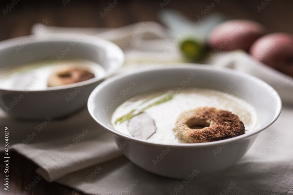 Close-up of leek soup served in bowls with tablecloth on table Close-up of leek soup served in bowls with tablecloth on table