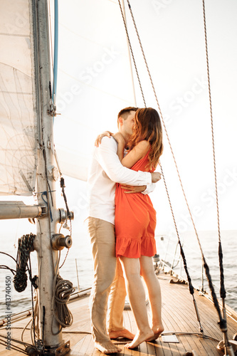 The moment of the marriage proposal, she said YES, the proposal on the yacht. The girl hugs her boyfriend. A loving couple are kissing.
