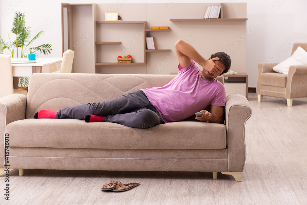 Young man watching tv at home during pandemic Young man watching tv at home during pandemic