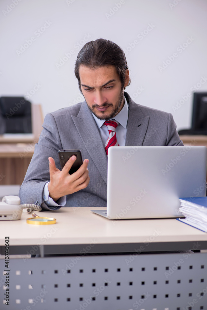 Young male employee working in the office Young male employee working in the office
