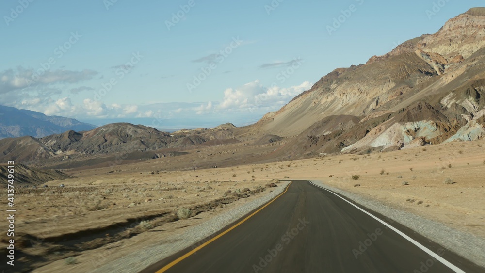 Road trip to Death Valley, Artists Palette drive, California USA. Hitchhiking auto traveling in America. Highway, colorful bare mountains and arid climate wilderness. View from car. Journey to Nevada.