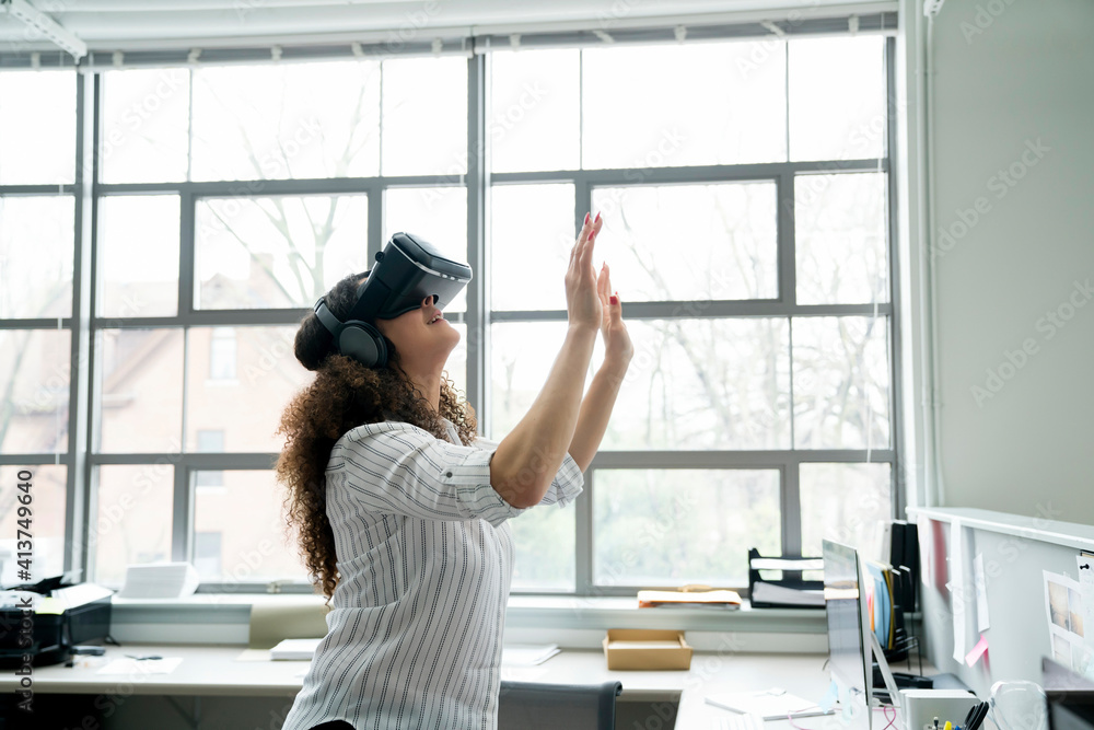 Businesswoman wearing virtual reality simulator in office Businesswoman wearing virtual reality simulator in office