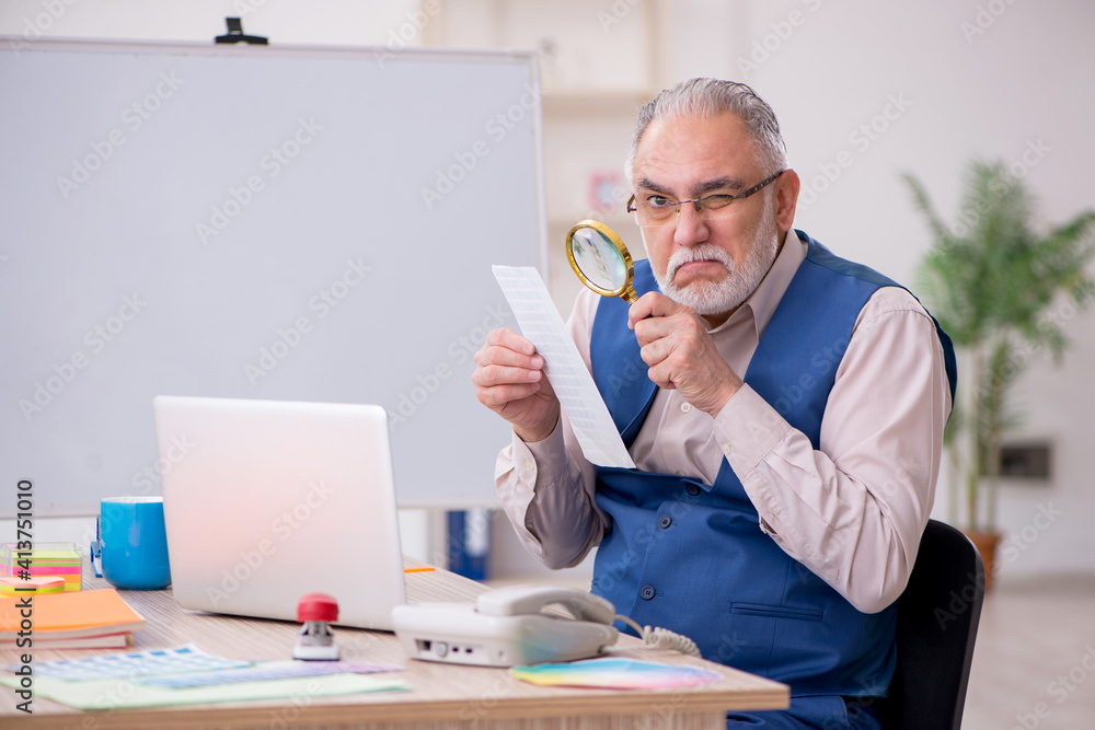 Old male designer working in the office Old male designer working in the office