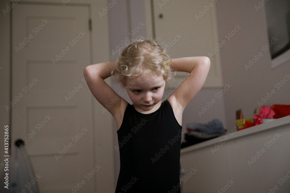 Girl tying hair while standing at home Girl tying hair while standing at home