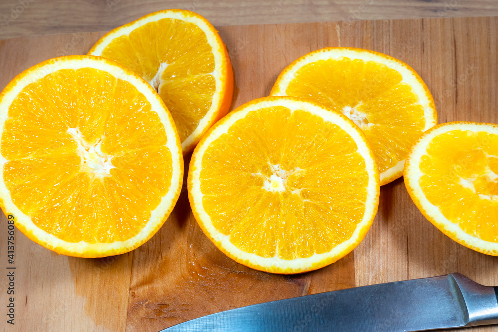 Many slices of orange lie on wooden kitchen board. Fresh citrus fruit.. Many slices of orange lie on wooden kitchen board. Fresh citrus fruit..