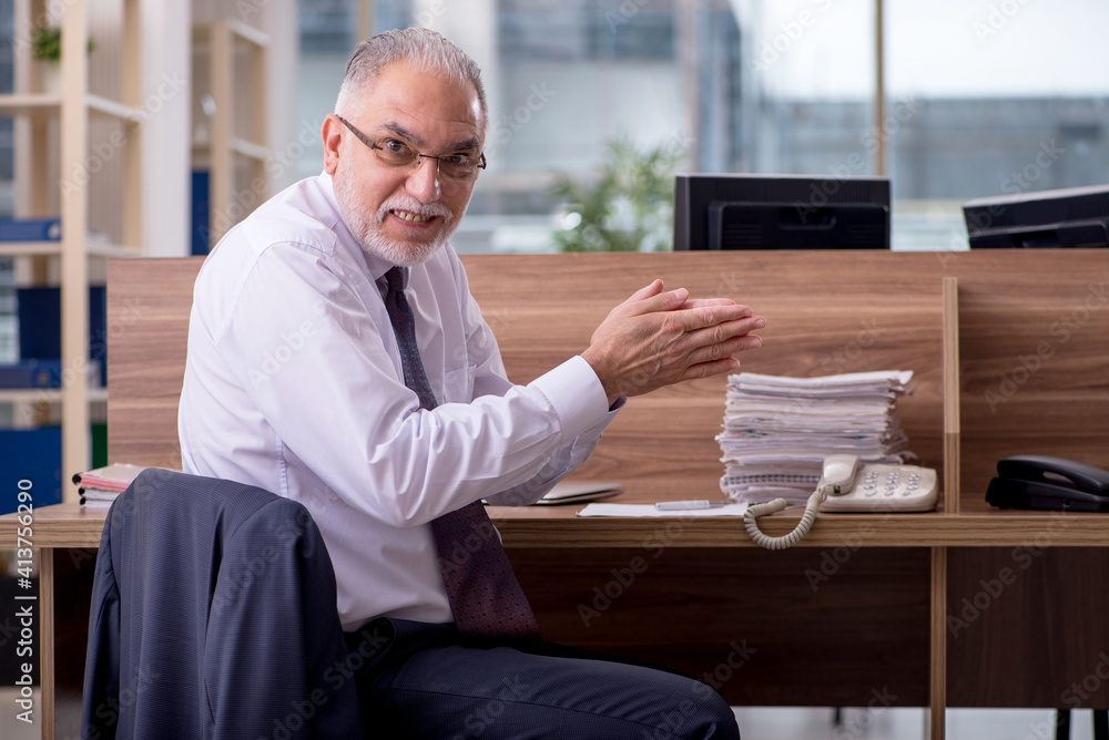Old male employee sitting in the office Old male employee sitting in the office