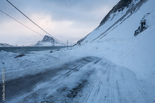Small snow avalance blocks Myrlandsveien - One of northern Norway's most Avalance and Rockfall prone roads, Flakstadøy, Lofoten Islands, Norway photo