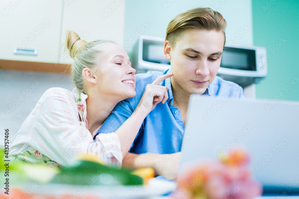 Young family. Wife flirts with husband sitting at laptop. Young family. Wife flirts with husband sitting at laptop.