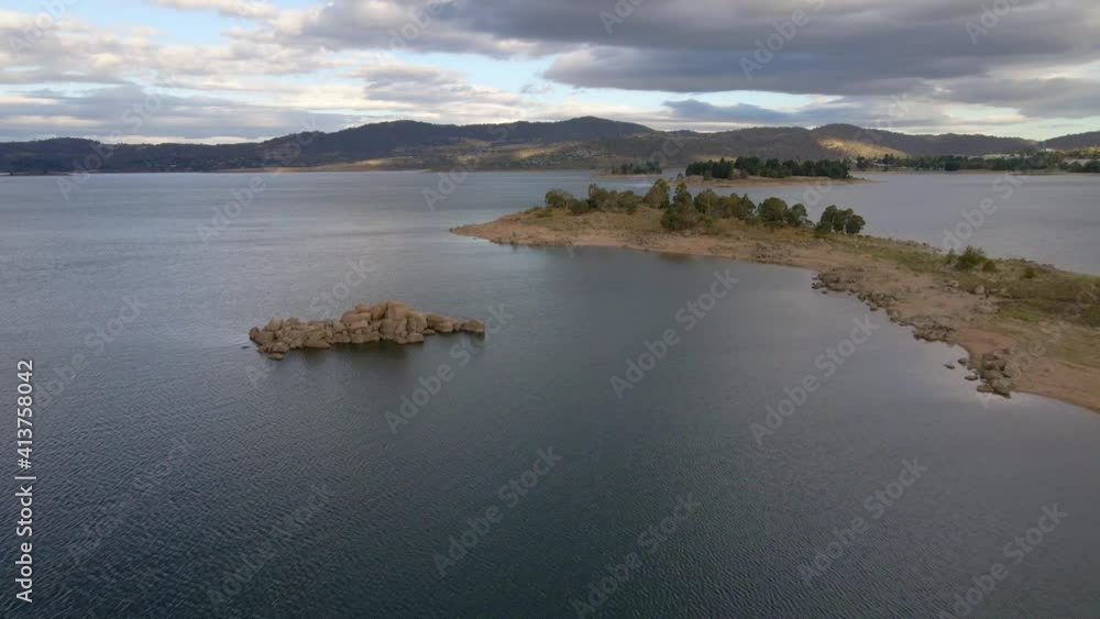 Aerial fly over rock formation in mountain lake Aerial fly over rock formation in mountain lake