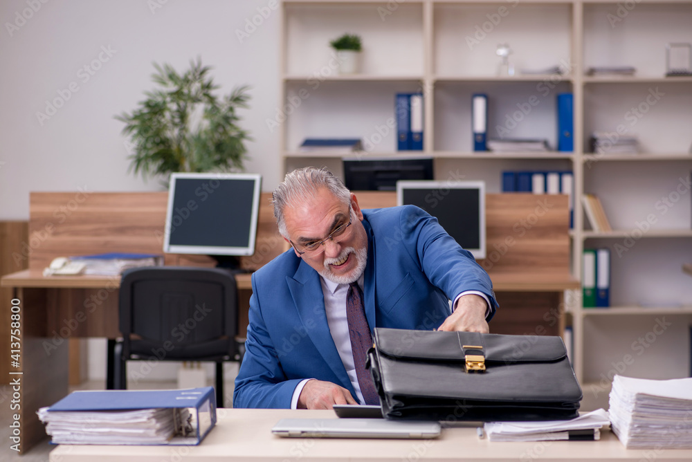 Old businessman employee in wheel-chair working in the office Old businessman employee in wheel-chair working in the office