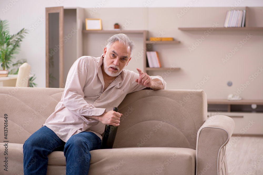 Old man drinking alcohol at home Old man drinking alcohol at home
