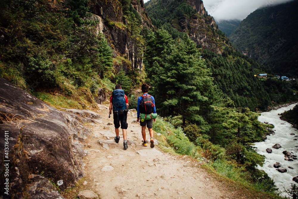 Rear view of friends with backpacks hiking at Sagarmatha National Park Rear view of friends with backpacks hiking at Sagarmatha National Park