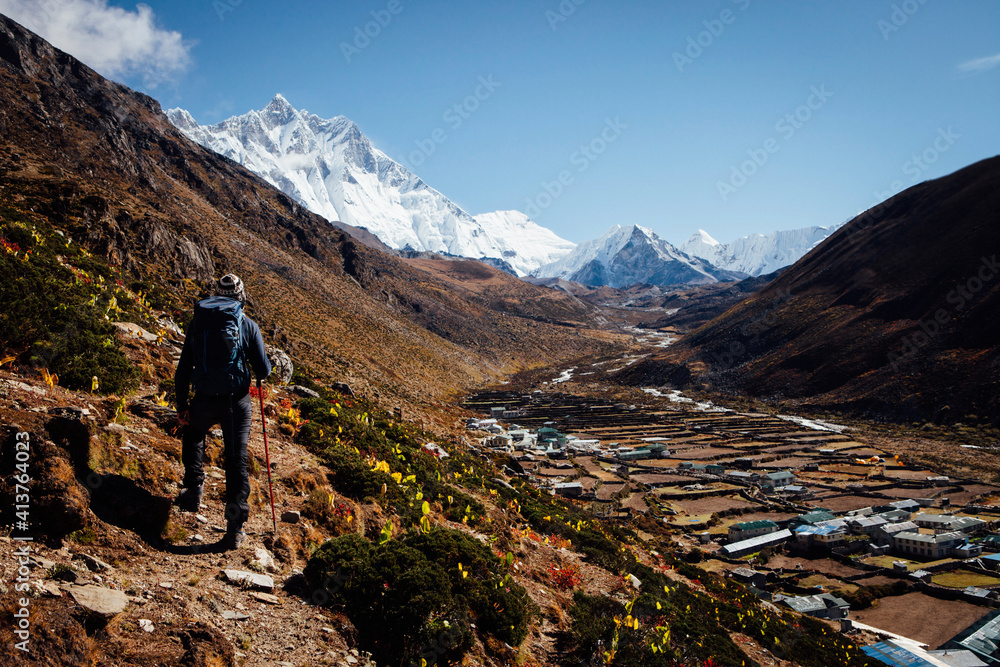 Rear view of hiker with backpack hiking on mountain against clear blue sky Rear view of hiker with backpack hiking on mountain against clear blue sky