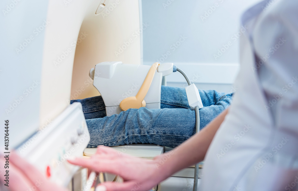 Obraz premium Radiologist prepares the patient for an MRI knee examination