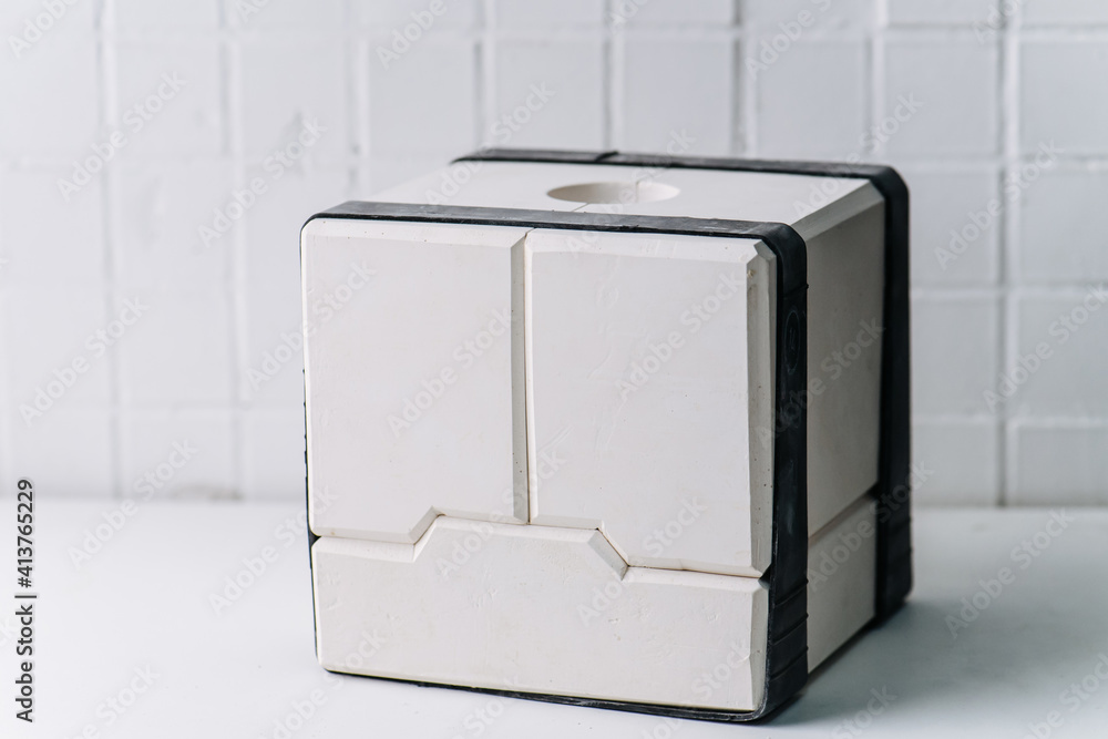 Modular gypsum plaster mold for making tableware. Reinforced with rubber bands. It's cube shaped, has white color. Modular gypsum plaster mold for making tableware. Reinforced with rubber bands. It's cube shaped, has white color.