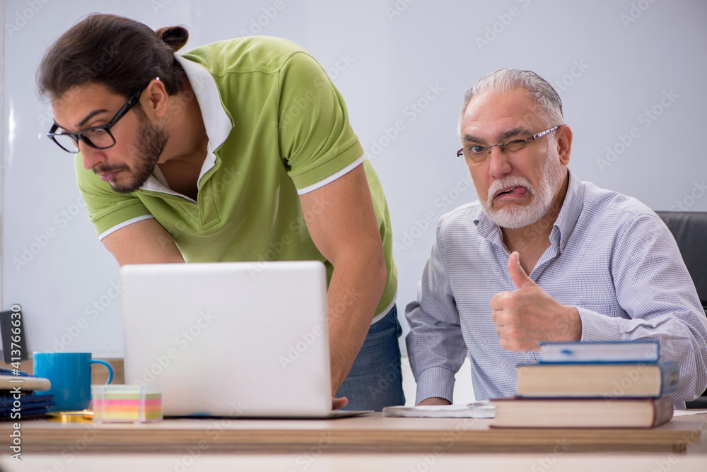 Fototapeta premium Old male teacher and young male student in the classroom
