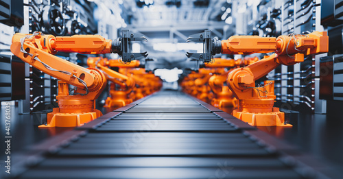 Robotic arms along assembly line in modern factory.