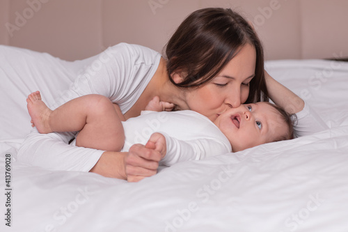 happy woman with baby lying on the bed photo