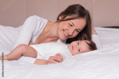 happy woman with baby lying on the bed photo