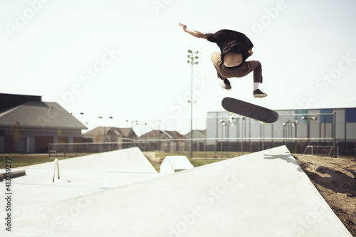 Young man performing stunts on skateboard photo