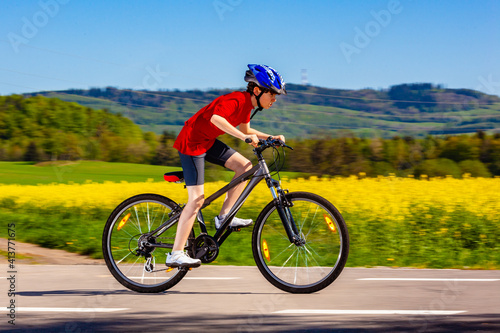 Teenage boy cycling on country road 