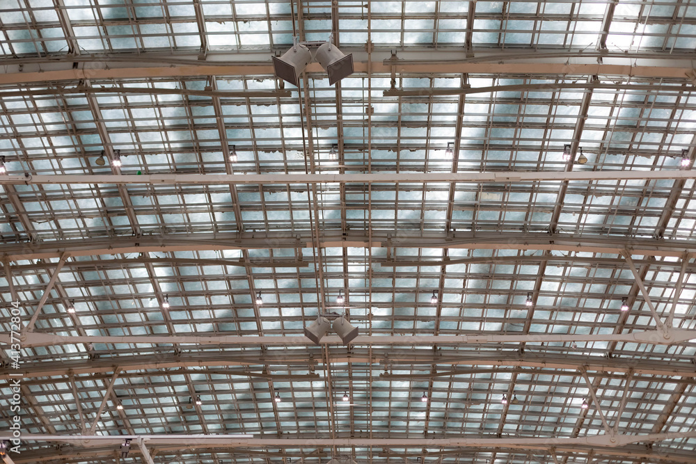 Glass roof on a metal frame. There is snow on top of the roof.