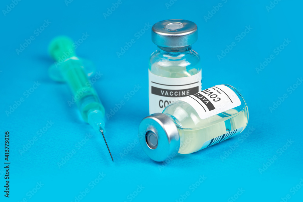 Vaccination. Syringe and vaccine COVID-19. Coronavirus on blue background Vaccination. Syringe and vaccine COVID-19. Coronavirus on blue background